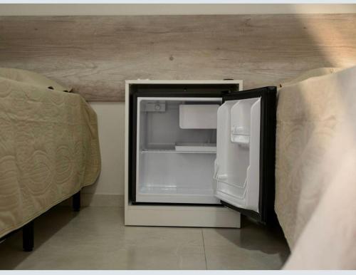an open refrigerator in the corner of a room at Pousada Aconchego in Ametista do Sul