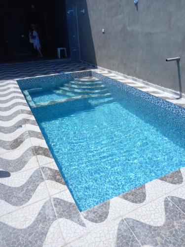 uma piscina com água azul num piso de azulejo em Casa de praia majorlandia em Majorlândia