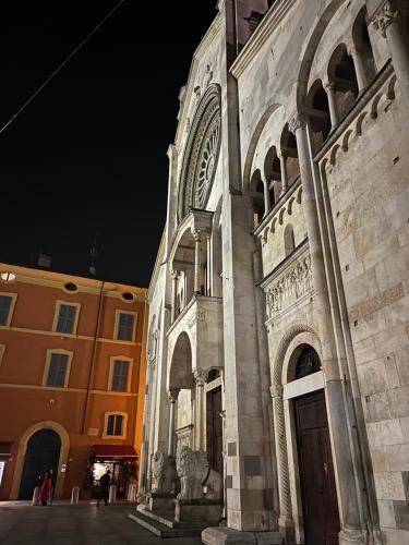 a large building with a clock tower at night at Loft Albinelli Wi-Fi e parcheggio gratis in centro in Modena