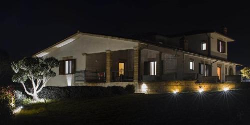 a house lit up at night with lights at agriturismo villa amerina in Corchiano