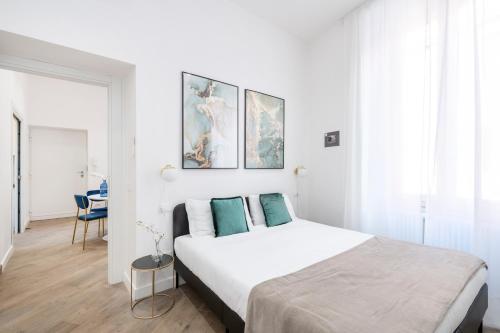 een slaapkamer met een groot wit bed met blauwe kussens bij White Flat Cross in Rome