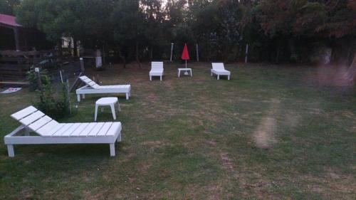 a group of white benches sitting in a yard at Las Hortensias Monoambiente in La Pedrera