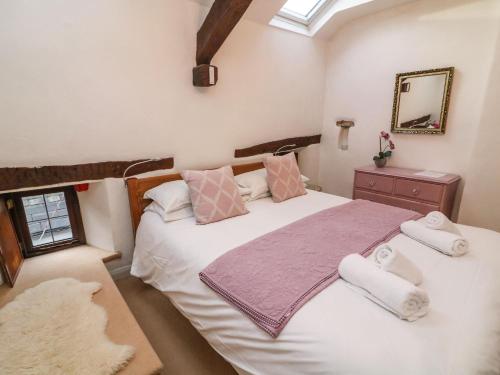una camera da letto con due letti e uno specchio di Courtyard Cottage a Kirkby Lonsdale