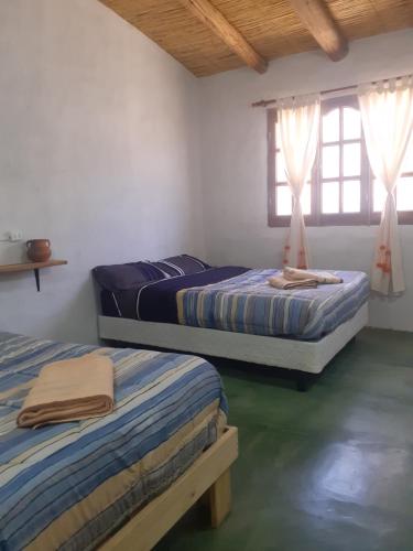 2 camas en una habitación con 2 ventanas en JN ALQUILERES en Maimará