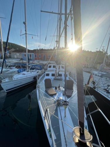 a boat docked in a marina with the sun shining at Sailing Yacht in Fiskardho