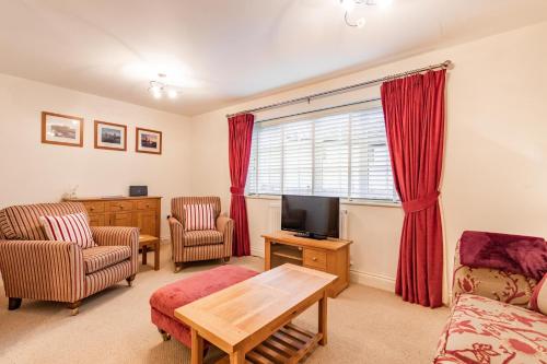 a living room with a couch and a tv at Broads Reach - Norfolk Holiday Properties in Stalham