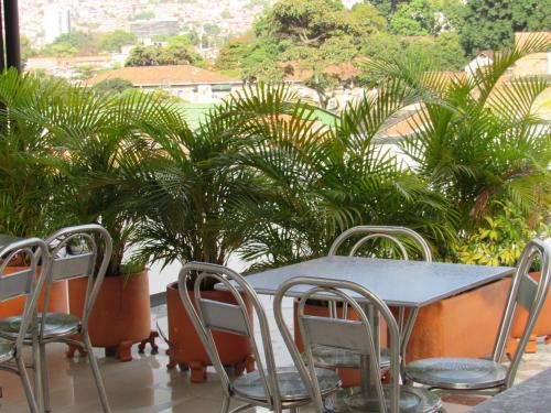 a table and chairs on a balcony with plants at Hotel Murano Medellín in Medellín