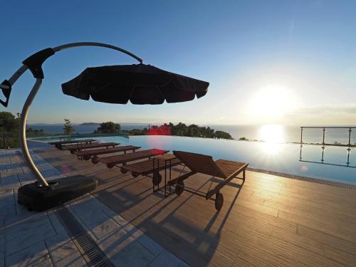 a group of chairs and an umbrella next to a pool at Villa Ventsislava in Metókhion Konstamonítou