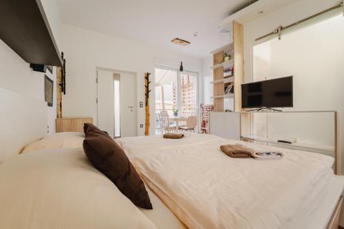 a bedroom with two beds and a flat screen tv at Naturasort Holiday Houses in Pesnica pri Mariboru