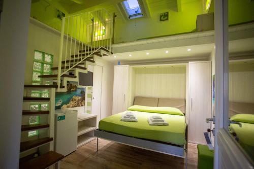 une chambre avec un lit vert et un escalier dans l'établissement Miramare Castellabate, à Santa Maria di Castellabate
