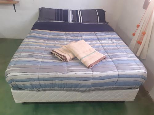 Una cama con dos almohadas encima. en JN ALQUILERES en Maimará