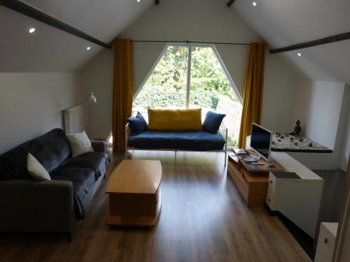a living room with a couch and a large window at T2 calme et chaleureux 1 à 5 pers in Alençon