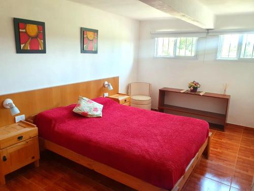 1 dormitorio con cama roja y escritorio en Doña Haydee en 