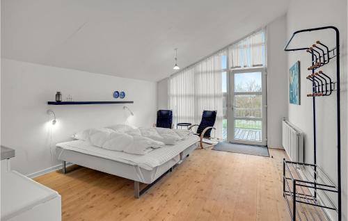 Dormitorio blanco con cama y ventana grande en Lovely Apartment In Hjer With Kitchen, en Højer