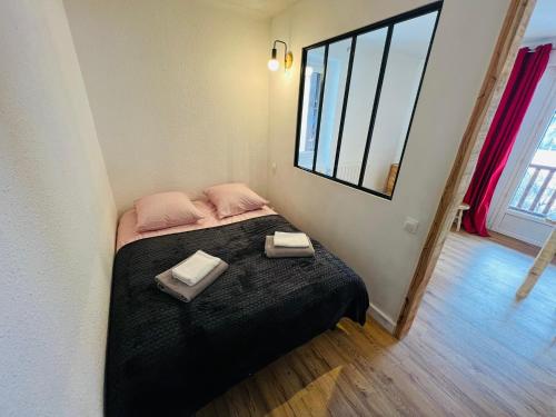 a bedroom with a bed with two towels on it at Studio Montagne - Plein Soleil et Terrasse in Briançon