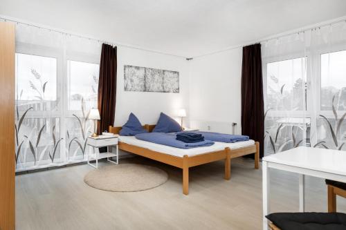 a bedroom with a bed with blue pillows at Pension Genat in Wedemark