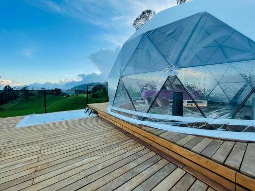 una cúpula de cristal sobre una terraza de madera en Stellarium Glamping, en Murillo