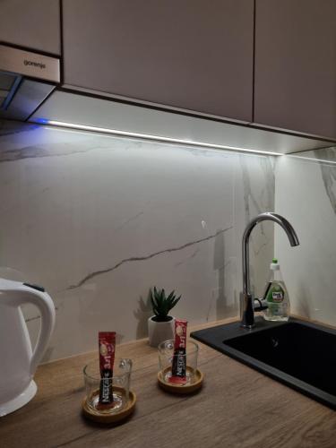 um balcão de cozinha com duas chávenas e um lavatório em M Lux Apartments em Banja Luka