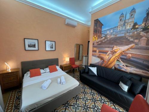 ローマにあるVirgilio Suiteのベッド2台とソファが備わるホテルルームです。