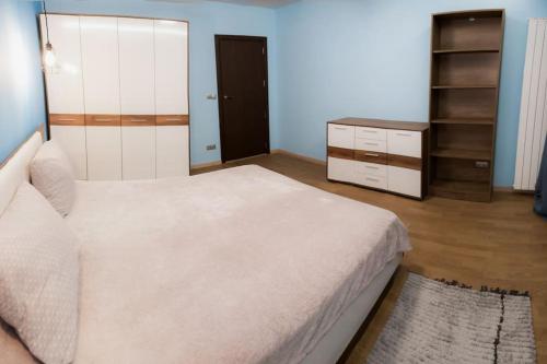um quarto com uma grande cama branca e uma cómoda em Very Spacious & Modern 3Bed near Airport & Centre em Sófia