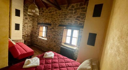una camera con un letto rosso e due finestre di Elpajardeportilla a León