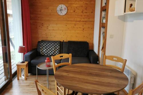 a living room with a couch and a table at Charmant T2 proche des pistes superbe vue in Chamrousse