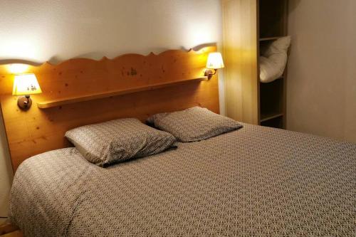 a bedroom with a bed with two pillows on it at Charmant T2 proche des pistes superbe vue in Chamrousse