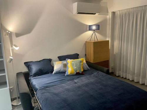 um quarto com uma cama com lençóis e almofadas azuis em Sea view apartment, huge terrace on the 4th floor em Menton