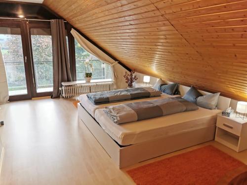 - une chambre avec un grand lit et un plafond en bois dans l'établissement Ferienwohnung Fichtner, à Stadtallendorf