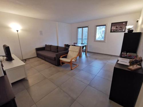 a living room with a couch and a table at Appartement Noisiel 77 (proche Disneyland & Paris) in Noisiel
