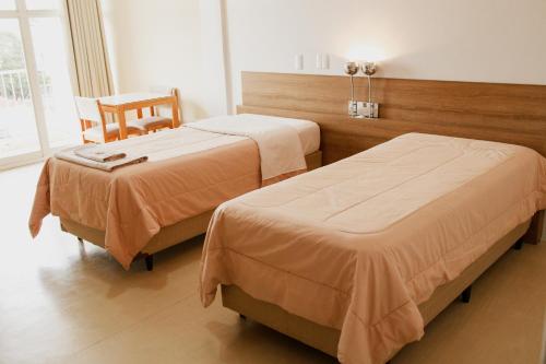 una habitación de hotel con 2 camas y una silla en Rigo Hotel en Santa Rosa