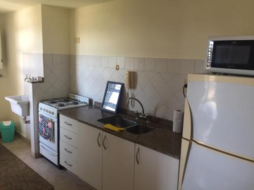 cocina con fregadero y nevera en Departamento familiar de un dormitorio. Excelente ubicación en Santa Fe