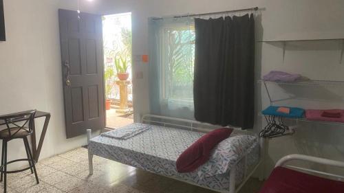a small room with a small bed and a window at Casa Natalia in Herradura