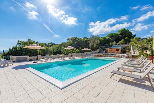 una piscina con sillas y sombrillas en un complejo en Brezza D'Estate, en Valderice