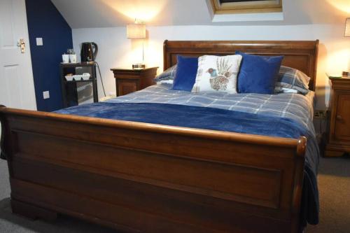 um quarto com uma grande cama de madeira com almofadas azuis em Fort William loft on shore front with amazing views em Caol
