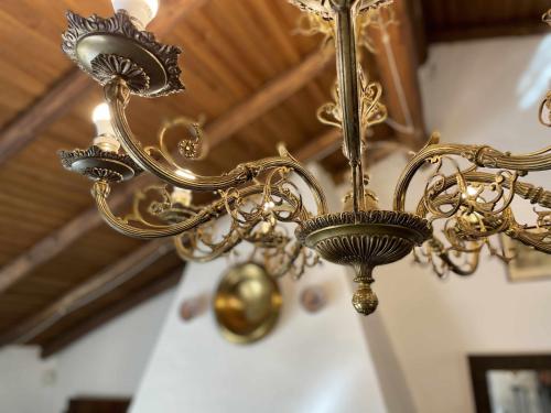 a gold chandelier hanging from a ceiling at La Alberguería complejo rural in Cañamero