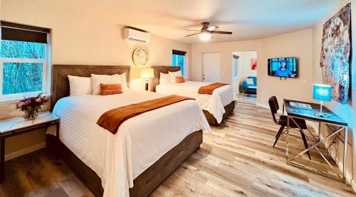 a hotel room with two beds and a television at West Sonoma Inn & Spa in Guerneville