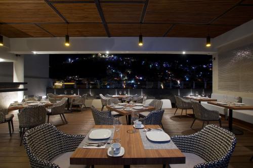グアナファトにあるNueve 25 Hotel Boutiqueのテーブルと椅子、大きな窓のあるレストラン