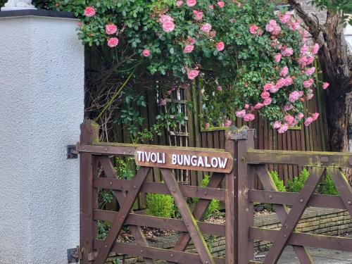 um portão de madeira com um sinal de madeira em Tivoli Bungalow em Weston-super-Mare