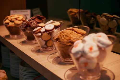 a group of cups filled with desserts on a shelf at Rigo Hotel in Santa Rosa