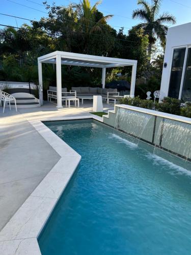 a swimming pool with a gazebo next to a house at Men only clothing option guesthouse near Wilton Manors in Fort Lauderdale