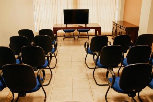 a room with chairs and a table and a television at Rigo Hotel in Santa Rosa