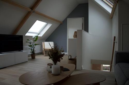 a living room with a table and a tv at Vakantiehuis 't Hertenkamp in Ouddorp