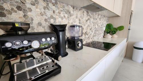 a kitchen counter with a coffee maker and a blender at Mama Taras Luxury Villa in Ngatangiia