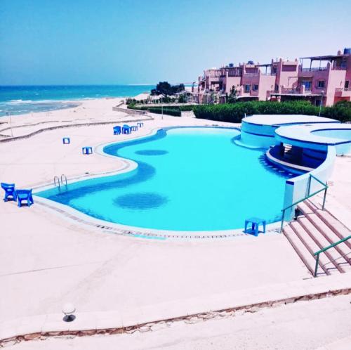 uma piscina numa praia junto ao oceano em Chalet with sea view استوديو باطلالة على البحر em Makman