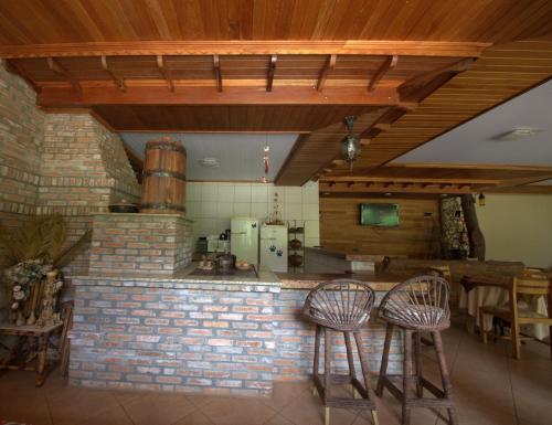 una cocina con 2 taburetes y una barra de ladrillo en Pousada Sonho Meu Foz, en Foz do Iguaçu