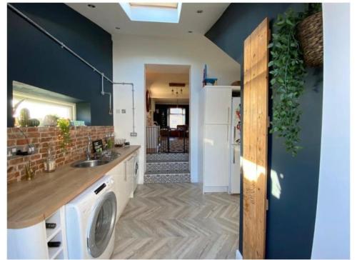 a kitchen with a washing machine in the middle of a room at Quirky 3 Bedroom house with great views in Pembrokeshire