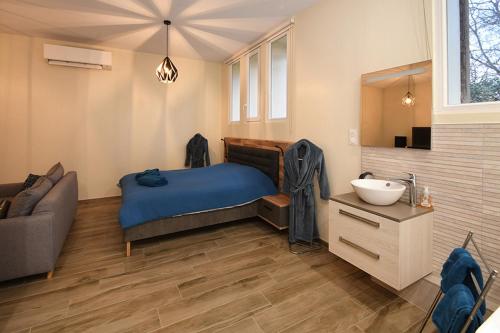 a bedroom with a bed and a sink and a couch at Appartement Loft Detente in Strasbourg