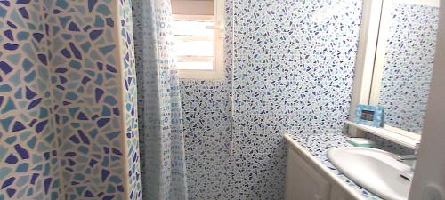 y baño con cortina de ducha y lavamanos. en le BLUE LAGOON, en Saint Martin