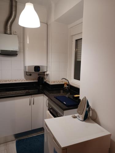 a kitchen with white cabinets and a sink at Apartment Estrela Heart in Lisbon